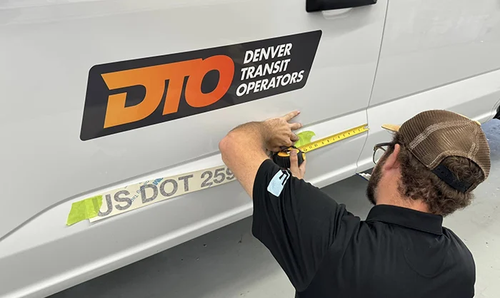 Fineline employee putting graphics on truck