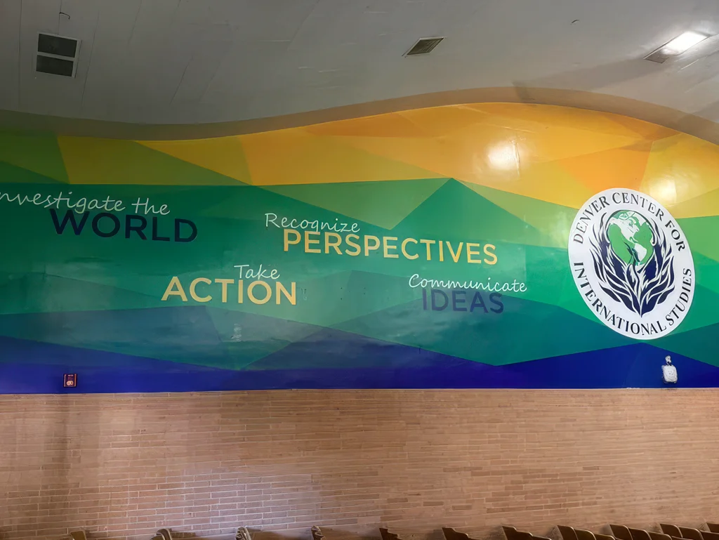 Large custom wall banner for Denver Center for International Studies featuring colorful geometric graphics, the school logo, and messages about perspective, action, and ideas.