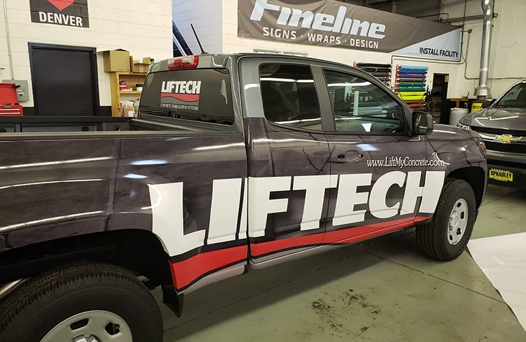 Fleet graphics on a LiftTech Concrete Solutions pickup truck featuring large company lettering, website information, and coordinated red, white, and black vehicle graphics.