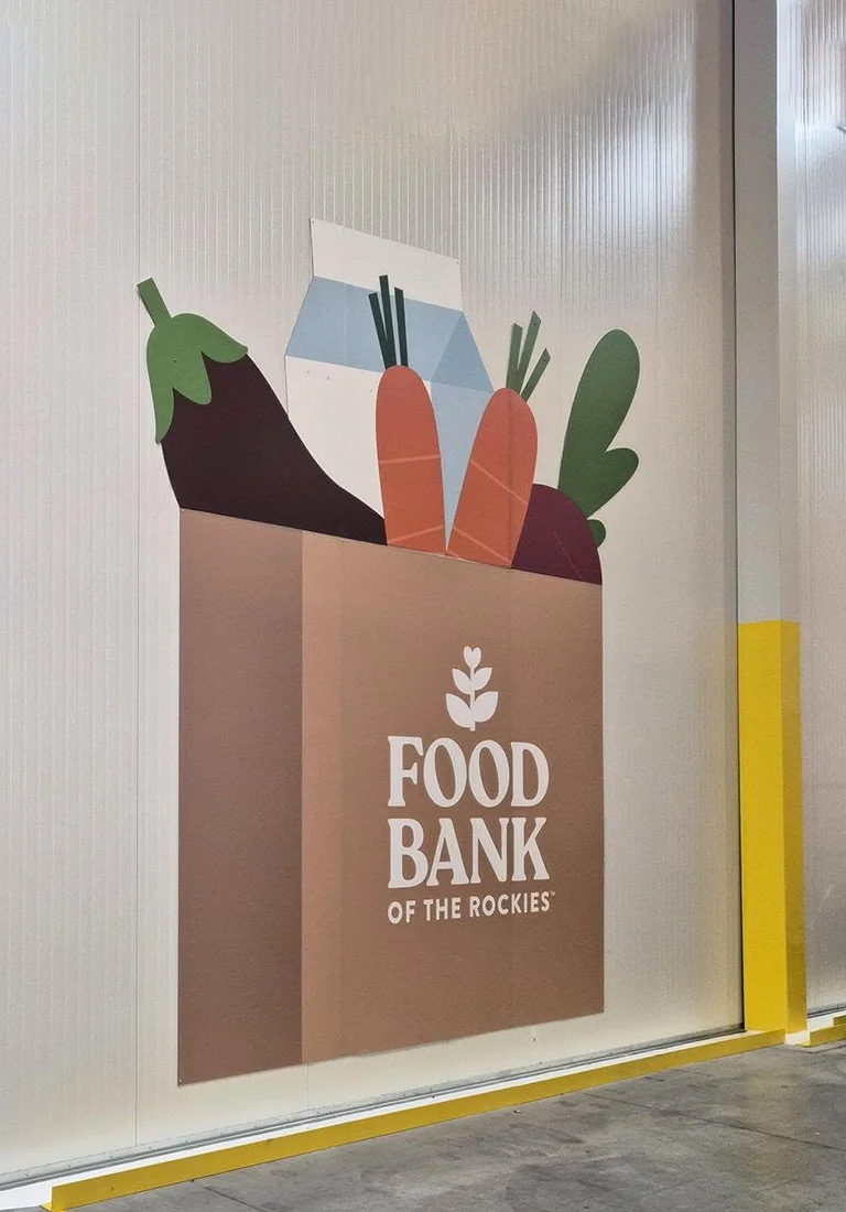 Custom wall graphic for Food Bank of the Rockies featuring a grocery bag illustration filled with food and the organization’s logo.