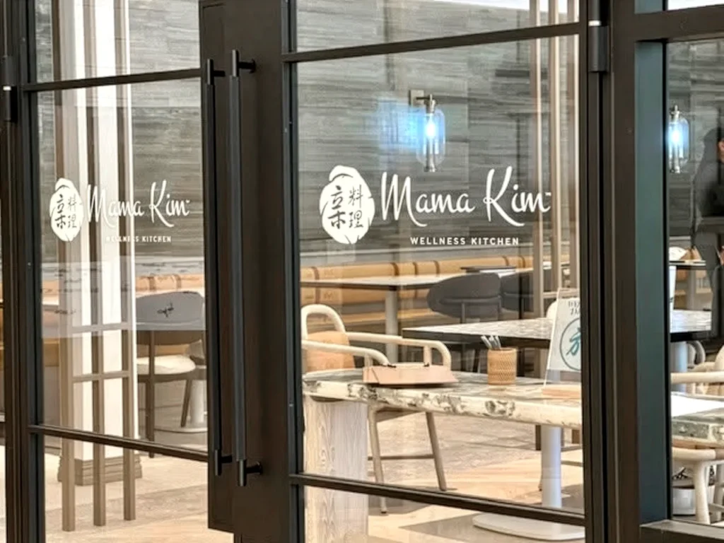 Custom Mama Kim Wellness Kitchen window graphics featuring the restaurant logo applied to interior glass doors and windows.